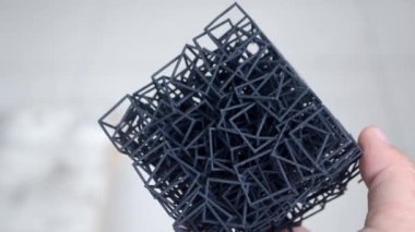 Adam 3D yazıcıya basılan el modelini tutuyor..