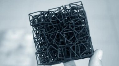 3D yazıcıya basılan el modelini tutan adam..