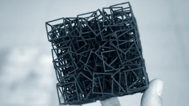 Чоловік тримає в руці модель, яка друкується на 3D принтері . — стокове відео