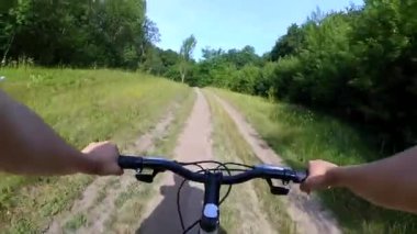 Yeşil bir ormanda bisiklet süren bisikletçi kız.