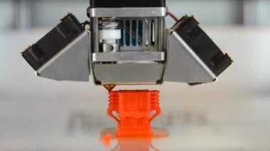 Yeni 3D yazıcı binası temiz düz yüzeyde izole edilmiş nesne turuncusu yazdırıyor