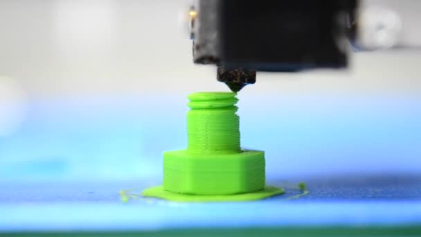 3D принтер делает или печатает болт модели, винт зеленого цвета крупным планом — стоковое видео