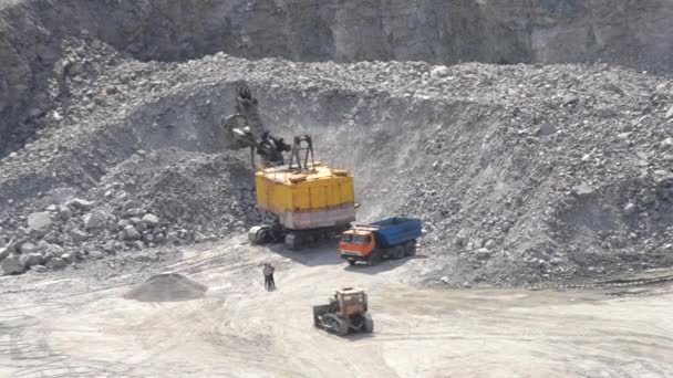 Big huge yellow excavator bucket scoops up large stones granite and pours close, — Stock Video