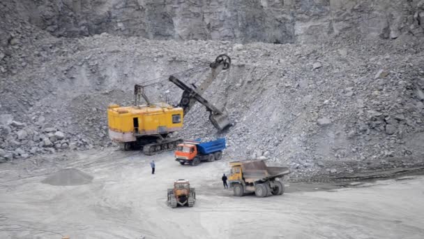 Enorme trabajo de cubo de excavadora amarilla en una cantera de granito — Vídeo de stock