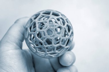 Endüstriyel toz 3D yazıcıya basılı nesne tutan kişi.