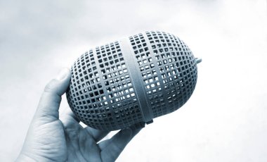 Pudra poliyamidinden üç boyutlu yazıcıya basılı nesne tutan kişi