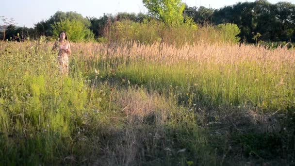 走在一条土路，长满草的女孩 — 图库视频影像