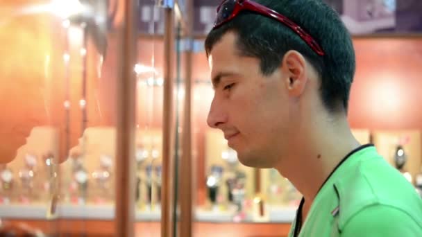 Young man standing near the windows in the store — Stock Video