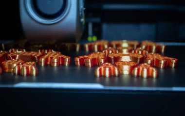 3D yazıcı kapat. 3 boyutlu yazıcı, erimiş turuncu plastikten bir şeyler yazdırıyor. 3D yazıcı, yazıcıdan sıvı plastik akışı ile model oluşturuyor. 3D yazdırma teknolojisi