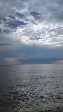 Denizde yağmur. Denize yağmur yağıyor. Bulutlu, yağmurlu, fırtınalı bir deniz. Suyun üzerinde kara yağmurlu bulutlar. Deniz, gökyüzü, bulutlar ve ufuk çizgisi. Deniz Burnu. Manzara manzarası. Doğa doğal arkaplan dikey