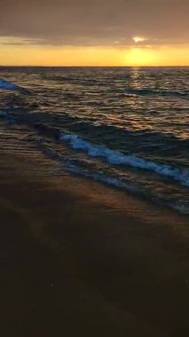 Denizde gün doğumu ya da gün batımı. Denizde yükselen ya da batan güneş. Kara yağmurlu bulutlarla gökyüzünde şafak. Gökyüzünde yağmurdan önce büyük bulutlarla gün batımı. Deniz yüzeyindeki güneş yolu. Doğa arkaplanı. Dikey