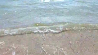 Turkuvaz şeffaf suyla güzel deniz dalgaları güneşli yaz gününde kumlu kumsalda yuvarlanıyor. Sessiz, sakin, rüzgarsız deniz. Düşük açı. Aşağıdan. Hiç kimse. Doğa arkaplanı. Doğal arkaplan