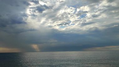 Denizde yağmur. Denize yağmur yağıyor. Bulutlu, yağmurlu, fırtınalı bir deniz. Suyun üzerinde kara yağmurlu bulutlar. Deniz, gökyüzü, bulutlar ve ufuk çizgisi. Deniz Burnu. Manzara manzarası. Doğa doğal arkaplan