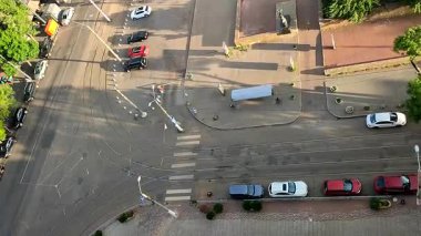 Güneşli bir yaz akşamında asfalt bir yol, hareket halindeki arabalar, raylar ve park edilmiş arabalar. Üst Manzara. Şehir manzarasının üstünden bak. Şehir manzarası. Şehir manzarası.