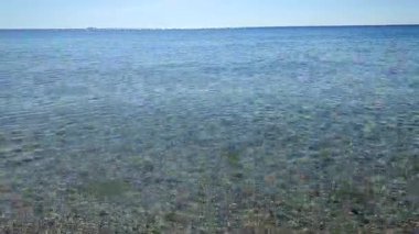 Deniz Burnu. Mavi deniz ve mavi gökyüzünün pürüzsüz deniz yüzeyi. Soyut deniz manzarası. Deniz manzarası. Skyline. Doğa arkaplanı. Doğal arka plan. Hiç kimse. Güneş parlıyor. Sakin güneşli hava. Küçük dalgalar