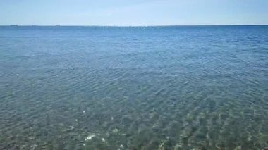 Deniz Burnu. Mavi deniz ve mavi gökyüzünün pürüzsüz deniz yüzeyi. Soyut deniz manzarası. Deniz manzarası. Skyline. Doğa arkaplanı. Doğal arka plan. Hiç kimse. Güneş parlıyor. Sakin güneşli hava. Küçük dalgalar