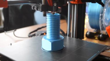 3D yazıcı bir nesne yazdırıyor. Bir 3D yazıcı, 3D yazıcının çalışma yüzeyine erimiş plastikten bir nesne basıyor. Bir 3D yazıcı bir model yaratıyor. Erimiş plastiğin yakın plan ekstrakderden akışı.