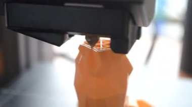 3D yazıcı bir nesne yazdırıyor. Bir 3D yazıcı, 3D yazıcının çalışma yüzeyine erimiş plastikten bir nesne basıyor. Bir 3D yazıcı bir model yaratıyor. Erimiş plastiğin yakın plan ekstrakderden akışı.