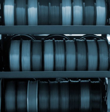 3D baskı için plastik tel makara. Plastik kapaklı farklı bir makara. 3D yazdırma bileşeni. Baskı aksesuarları. 3 boyutlu baskı teknolojisi kavramı. Katkı sağlayan yenilikçi FDM teknolojileri