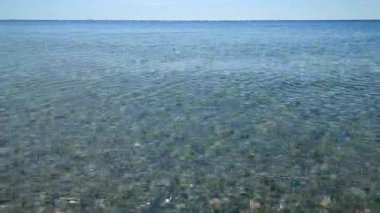 Deniz Burnu. Mavi deniz ve mavi gökyüzünün pürüzsüz deniz yüzeyi. Soyut deniz manzarası. Deniz manzarası. Skyline. Doğa arkaplanı. Doğal arka plan. Hiç kimse. Güneş parlıyor. Sakin güneşli hava. Küçük dalgalar