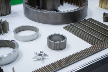 Beyaz bir yüzeyde farklı metal modeller. Birçok metal ürünü yakın planda. Vitesin çeşitli metal parçaları. Vites tekerlekleri. Metal işleme. Endüstriyel metal nesneler. Çelik imalatı