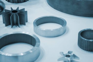Beyaz bir yüzeyde farklı metal modeller. Birçok metal ürünü yakın planda. Vitesin çeşitli metal parçaları. Vites tekerlekleri. Metal işleme. Endüstriyel metal nesneler. Çelik imalatı