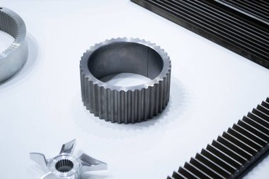 Beyaz bir yüzeyde farklı metal modeller. Birçok metal ürünü yakın planda. Vitesin çeşitli metal parçaları. Vites tekerlekleri. Metal işleme. Endüstriyel metal nesneler. Çelik imalatı