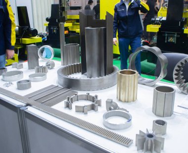 Beyaz bir yüzeyde farklı metal modeller. Birçok metal ürünü yakın planda. Vitesin çeşitli metal parçaları. Vites tekerlekleri. Metal işleme. Endüstriyel metal nesneler. Çelik imalatı