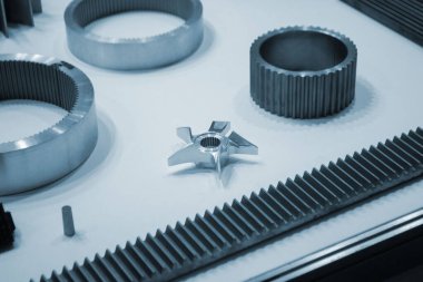 Beyaz bir yüzeyde farklı metal modeller. Birçok metal ürünü yakın planda. Vitesin çeşitli metal parçaları. Vites tekerlekleri. Metal işleme. Endüstriyel metal nesneler. Çelik imalatı