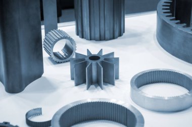 Beyaz bir yüzeyde farklı metal modeller. Birçok metal ürünü yakın planda. Vitesin çeşitli metal parçaları. Vites tekerlekleri. Metal işleme. Endüstriyel metal nesneler. Çelik imalatı