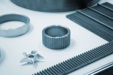 Beyaz bir yüzeyde farklı metal modeller. Birçok metal ürünü yakın planda. Vitesin çeşitli metal parçaları. Vites tekerlekleri. Metal işleme. Endüstriyel metal nesneler. Çelik imalatı