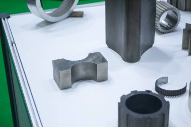 Beyaz bir yüzeyde farklı metal modeller. Birçok metal ürünü yakın planda. Vitesin çeşitli metal parçaları. Vites tekerlekleri. Metal işleme. Endüstriyel metal nesneler. Çelik imalatı