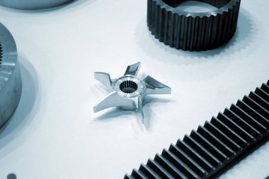 Beyaz bir yüzeyde farklı metal modeller. Birçok metal ürünü yakın planda. Vitesin çeşitli metal parçaları. Vites tekerlekleri. Metal işleme. Endüstriyel metal nesneler. Çelik imalatı