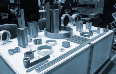 Beyaz bir yüzeyde farklı metal modeller. Birçok metal ürünü yakın planda. Vitesin çeşitli metal parçaları. Vites tekerlekleri. Metal işleme. Endüstriyel metal nesneler. Çelik imalatı