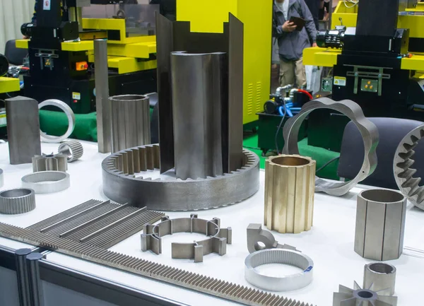 Beyaz bir yüzeyde farklı metal modeller. Birçok metal ürünü yakın planda. Vitesin çeşitli metal parçaları. Vites tekerlekleri. Metal işleme. Endüstriyel metal nesneler. Çelik imalatı