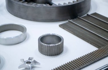 Beyaz bir yüzeyde farklı metal modeller. Birçok metal ürünü yakın planda. Vitesin çeşitli metal parçaları. Vites tekerlekleri. Metal işleme. Endüstriyel metal nesneler. Çelik imalatı