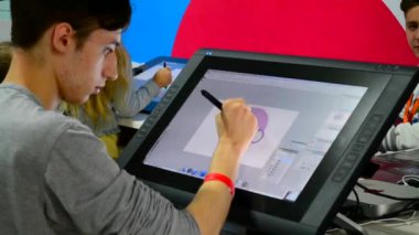 Genç çocuk bir çok büyük bilgisayar tablet üzerinde çizer