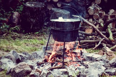 turist su ısıtıcısı yiyecek bir kamp ateşi üzerinde kaynar