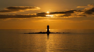Mangiabarche 'ın deniz feneri sakin bir günbatımında, sonbahar günü