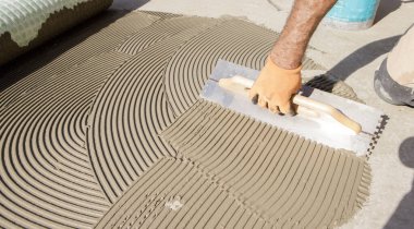 Yere tutkal süren bir işçi.