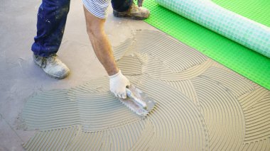 Yere tutkal süren bir işçi.