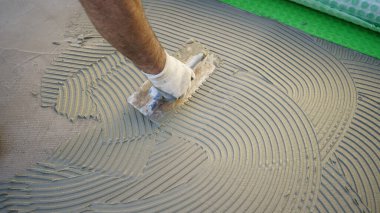 Yere tutkal süren bir işçi.