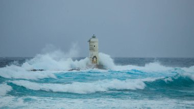 Mangiabarche 'ın deniz feneri mistral bir fırtınanın dalgalarıyla örtülü.