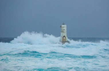 Mangiabarche 'ın deniz feneri mistral bir fırtınanın dalgalarıyla örtülü.