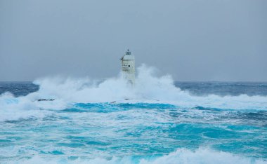 Mangiabarche 'ın deniz feneri mistral bir fırtınanın dalgalarıyla örtülü.