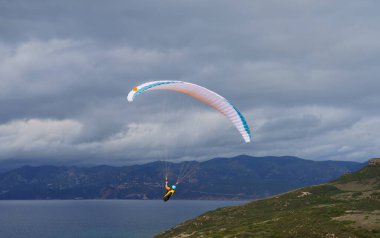 Sardunya 'nın güneyindeki dağlarda paraglid uçuşu.