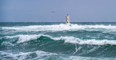 Mangiabarche 'ın deniz feneri mistral bir fırtınanın dalgalarıyla örtülü.