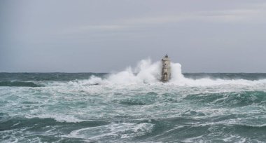 Mangiabarche 'ın deniz feneri mistral bir fırtınanın dalgalarıyla örtülü.