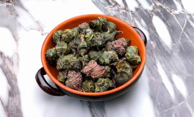 Freshly harvested bocconi sea snails resting in a rustic terracotta bowl
