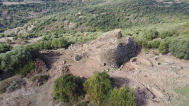 View of the Nuraghe Iloi archaeological site in Sedilo, Sardinia, featuring ancient basalt stone walls and panoramic landscape